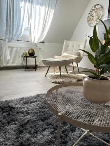 sala de estar con mesa y maceta en Deluxe Apartment en Duisburg