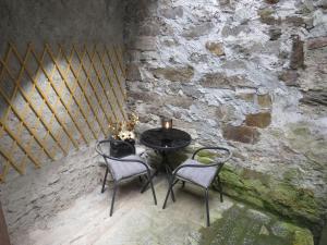 stół i 2 krzesła w pokoju z kamienną ścianą w obiekcie Marta's house w mieście Prebernardo