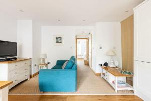 a living room with a blue couch and a table at Dukes House - first floor apartment in Padstow