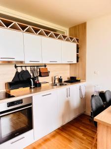 a kitchen with white cabinets and a sink at Apartman Bjelašnica in Bjelašnica