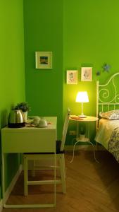 Habitación verde con cama y mesa con lámpara en B&B Stella Scugnizza, en Nápoles