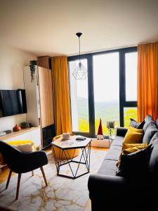 a living room with a couch and a table at Apartman Bjelašnica in Bjelašnica +35 photos