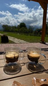 dwie szklanki kawy siedzące na stole w obiekcie Little Bear Lodge w Sybinie