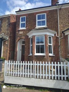 a white fence in front of a brick house at Number 9 in Hunstanton
