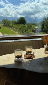 two glasses sitting on a table in front of a window at Little Bear Lodge in Sibiu