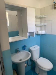a blue bathroom with a toilet and a sink at Villas Ermali in Ksamil