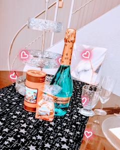 uma garrafa de champanhe sentada numa mesa com copos em Jolie maison de village em Capendu