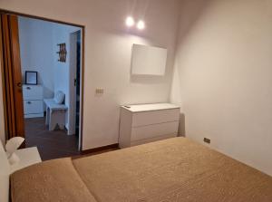 1 dormitorio con cama, tocador y espejo en Villetta d' aMare, en Avola