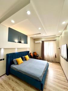 - une chambre avec un lit bleu et des oreillers jaunes dans l'établissement Old City Apartment, à Baku