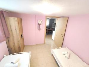 a bathroom with pink walls and a tub and a mirror at Vaso apartment Limenaria Thasos in Limenaria +8 photos