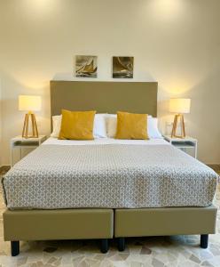 Villa Magnolia في فورميا: غرفة نوم بسرير كبير فيها مصباحين