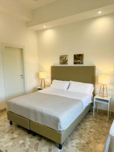 a bedroom with a large bed and two lamps at Villa Magnolia in Formia