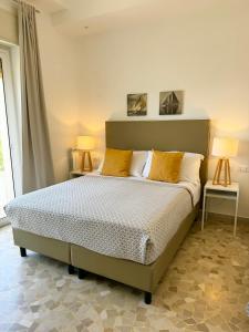 una camera da letto con un letto con due lampade sopra di Villa Magnolia a Formia