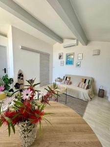 un soggiorno con un divano e un vaso di fiori di Nid douillet vue mer Hyères a Hyères