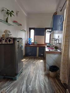 kuchnia z niebieskimi szafkami i lodówką ze stali nierdzewnej w obiekcie Lasaya apartment w mieście Siliguri