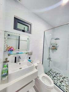 a white bathroom with a sink and a toilet at Apec Sunsea Condotel Phu Yen in Liên Trì (3)
