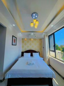 a bedroom with a large bed and a window at Apec Sunsea Condotel Phu Yen in Liên Trì (3)
