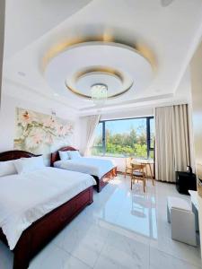 a large bedroom with two beds and a chandelier at Apec Sunsea Condotel Phu Yen in Liên Trì (3)
