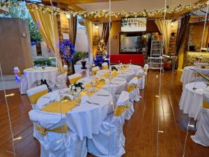 une rangée de tables avec des nappes blanches dans une pièce dans l'établissement Hôtel La Belle Etoile & SPA, à Saly Portudal