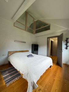 a bedroom with a large white bed in a room at Karkle SummerHOUSE, sea view villa in Karklė