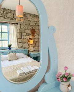 1 dormitorio con cama y espejo en Dort Mevsim Alacati, en Alacati