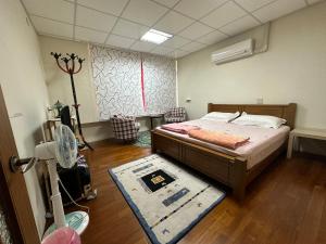 a bedroom with a bed and a rug in a room at 枋寮枋居背包客棧Fang Ju Backpackers in Fangliao