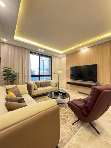 sala de estar con sofá, sillas y TV en Khozama Living 2 - Alnahda, en Yeda