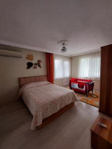 um quarto com uma cama e uma cadeira vermelha em Hânetül Mabeyn em Rize