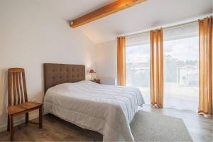 a bedroom with a bed and a large window at Les Lilas in Podensac