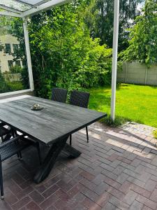 una mesa de madera y sillas en un patio en Kapitänshaus an der Warnow mit Sauna en Rostock