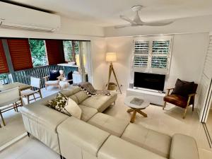 uma sala de estar com um sofá e uma televisão em Noosa Beach Apartment on HASTING ST French quarter resort.Noosa Heads em Noosa Heads