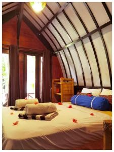 Un dormitorio con dos camas con flores rojas. en Ardi Beltza Hotel and Private Pool Villa en Gili Air
