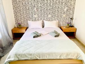 a bedroom with a white bed with two night stands at Skopelos Inn in Stafylos
