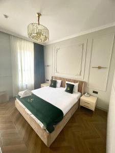 een slaapkamer met een groot bed en een kroonluchter bij Perla De Mar Hotel in Baku
