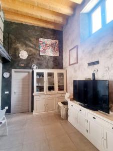 salon z dużym telewizorem i ścianą w obiekcie Casa vacanza in lipari ,PIANO PIANO w mieście Lipari