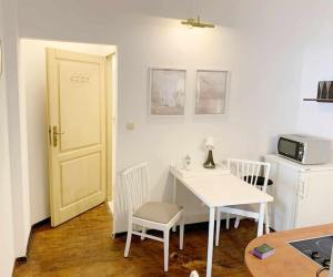 una cucina con tavolo e sedie bianchi e forno a microonde di Wygodny apartament Piotrkowska a Łódź Altre 3 foto