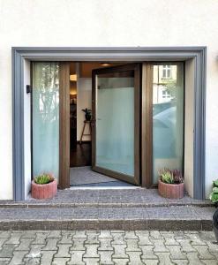 una porta di vetro di un edificio con due piante in vaso di Wygodny apartament Piotrkowska a Łódź