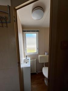 a bathroom with a toilet and a sink and a window at Seaview Holiday Rentals - Seawall in Whitstable