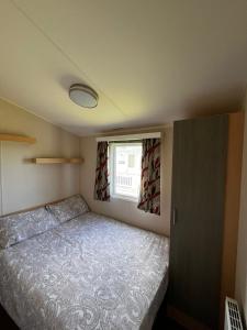 a small bedroom with a bed and a window at Seaview Holiday Rentals - Seawall in Whitstable