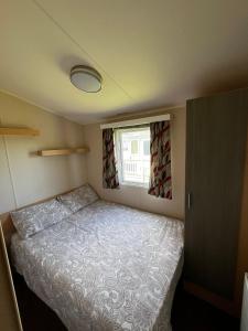 a small bedroom with a bed and a window at Seaview Holiday Rentals - Seawall in Whitstable