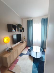 uma sala de estar com uma televisão e uma mesa de vidro em Apartments Marijana em Vodice