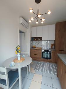 uma cozinha com uma mesa branca, uma mesa e cadeiras em Apartments Marijana em Vodice