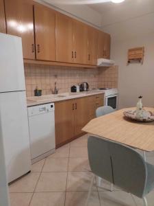 a kitchen with a white refrigerator and a table with chairs at Boho Zen Retreat in Agia Pelagia