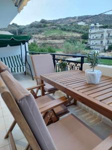 a wooden table and chairs on a balcony at Boho Zen Retreat in Agia Pelagia