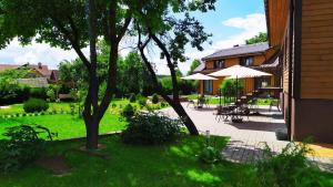 un patio con mesas y sombrillas junto a una casa en "Trakaitis" nameliai en Trakai