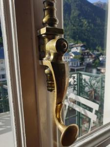une poignée de porte en or sur une fenêtre avec vue dans l'établissement Majestic T2 calme, spacieux, central, avec parking, à Chamonix-Mont-Blanc