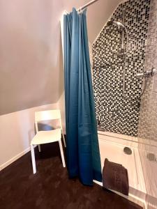 um chuveiro com uma cortina de chuveiro azul ao lado de uma cadeira em Apartment No.9 em Husum