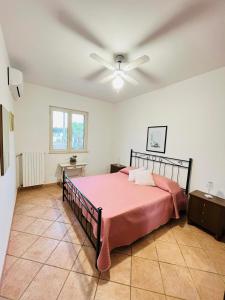 Fusella Country House/Villa a Polignano Vista Mare في بولينيانو آ ماري: غرفة نوم بسرير ومروحة سقف