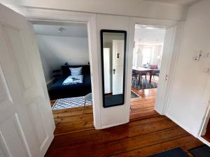 a hallway with a mirror and a room with a bed at Apartment No.9 in Husum