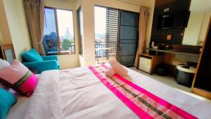 a bedroom with a large bed with a large window at Lucky Buako Hotel Patong in Patong Beach